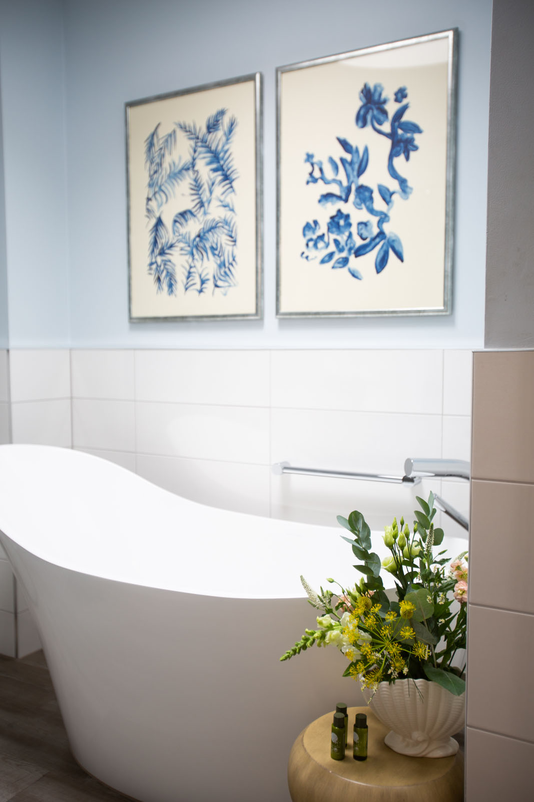 free standing slipper bath in blue bathroom, fresh flowers, bubble bath